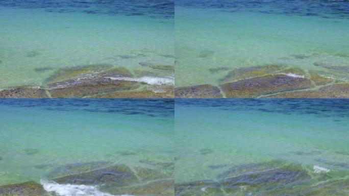 热带海滩附近有石头的透明透明水的特写视图