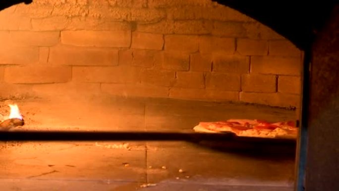 把披萨放在木头上的披萨烤箱里