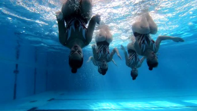 快乐的女游泳运动员在练习中向水下的相机挥手