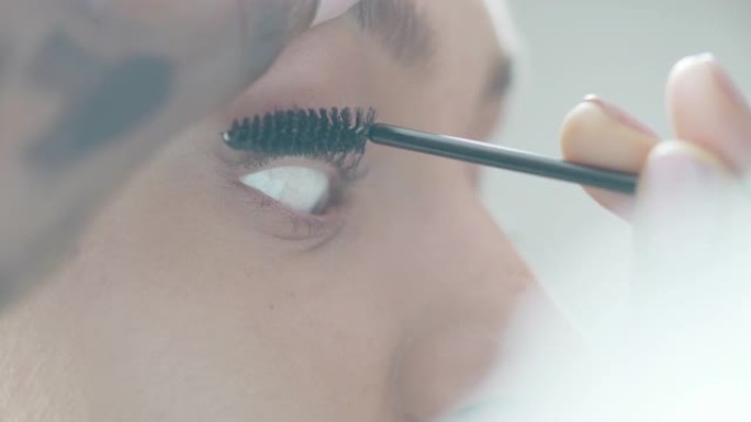 美容师将睫毛膏涂在模特睫毛上的特写镜头