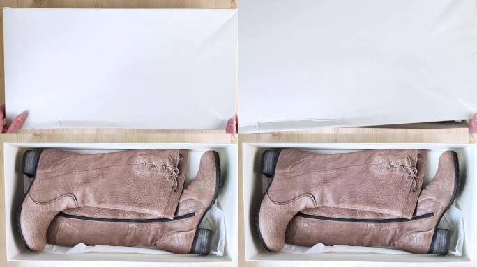 棕色女靴躺在白色盒子里。盒子打开了