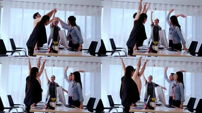 成功的商界人士在办公室庆祝项目成功。