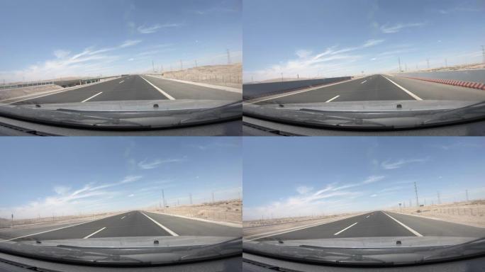 戈壁沙漠高速公路上驾驶汽车，POV前挡风玻璃