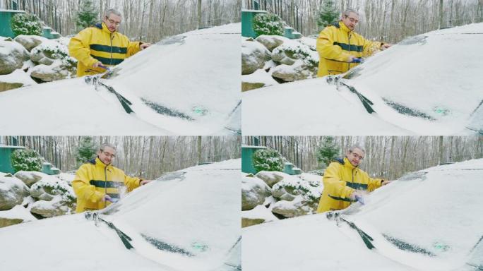 成熟的男人在冰雪中清洗汽车。