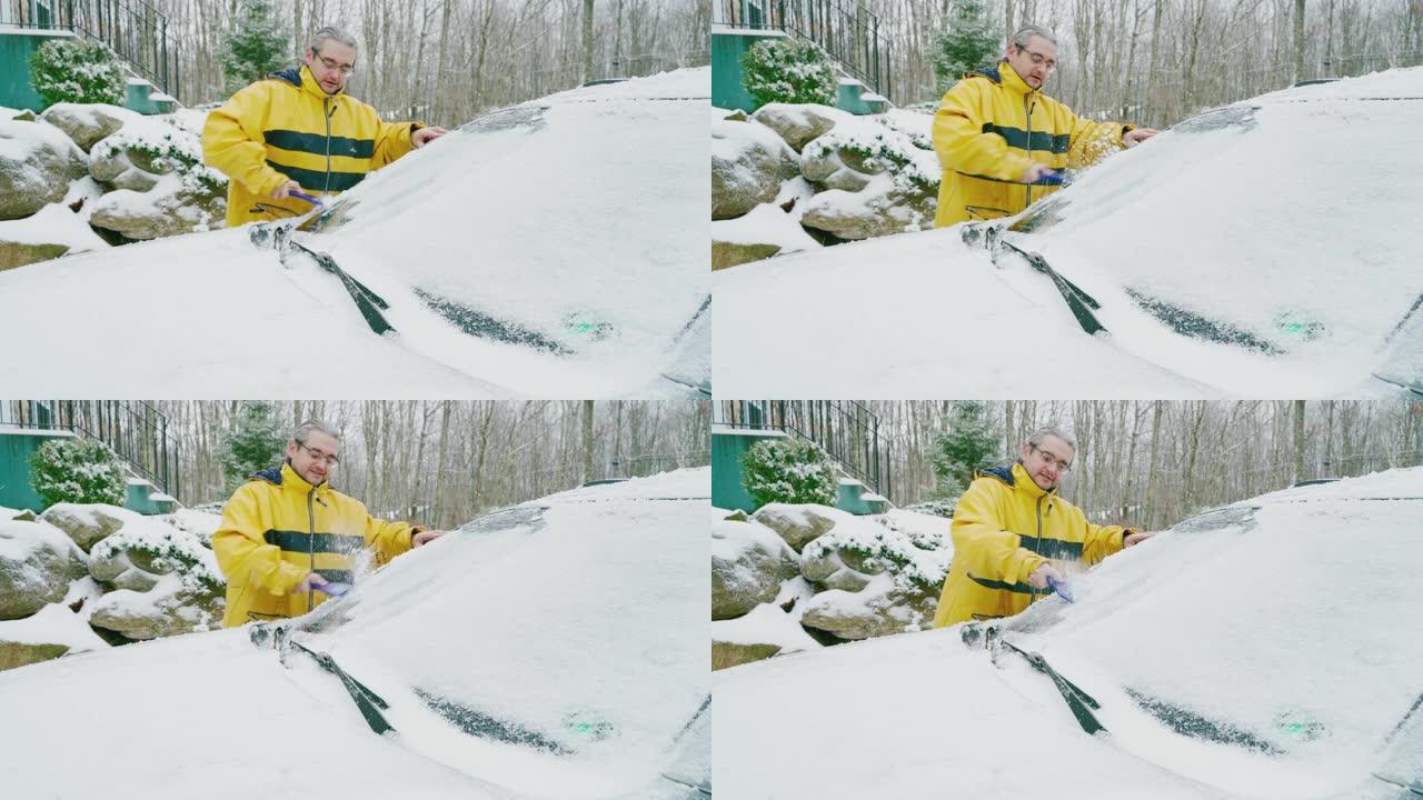 成熟的男人在冰雪中清洗汽车。