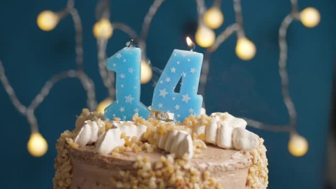 蓝色背景上有14个数字蜡烛的生日蛋糕。蜡烛吹灭了。慢动作和特写视图