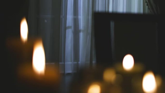 机架集中在停电期间照亮黑暗房屋的一组蜡烛上。