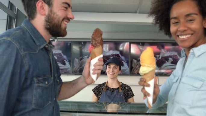 女工在冰淇淋店为一对夫妇提供冰淇淋