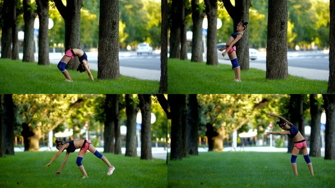 一个阳光明媚的夏日，在城市公园的草地上，穿着运动服的七年美丽的高加索女孩练习体操。慢动作