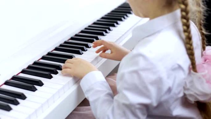 小女孩在白色钢琴上演奏古典音乐