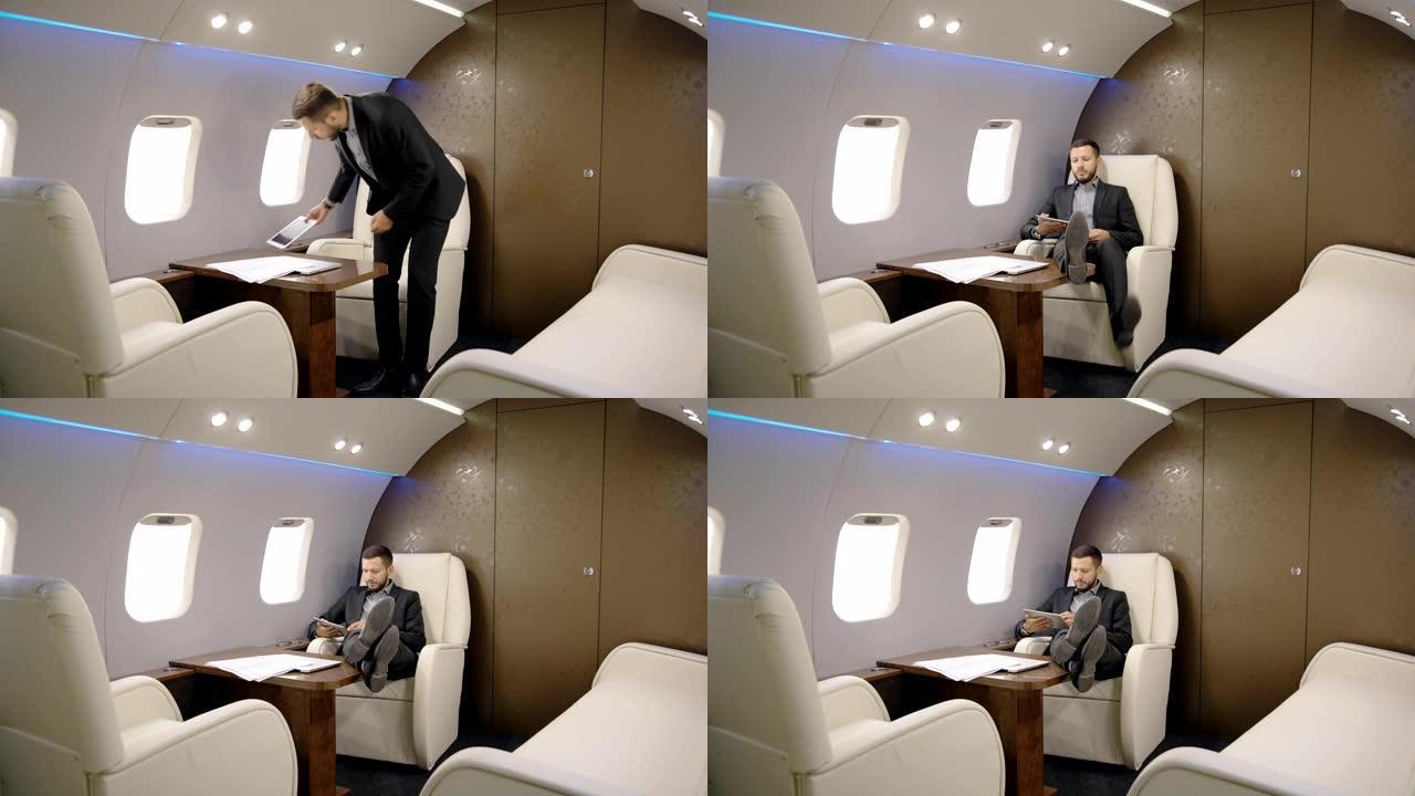 律师成功的人在私人飞机上坐下并在平板电脑上阅读新闻的肖像。企业家飞机
