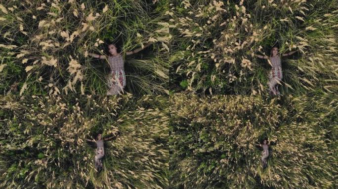 高加索嬉皮士女孩仰面躺在干草田里。自然之子的概念