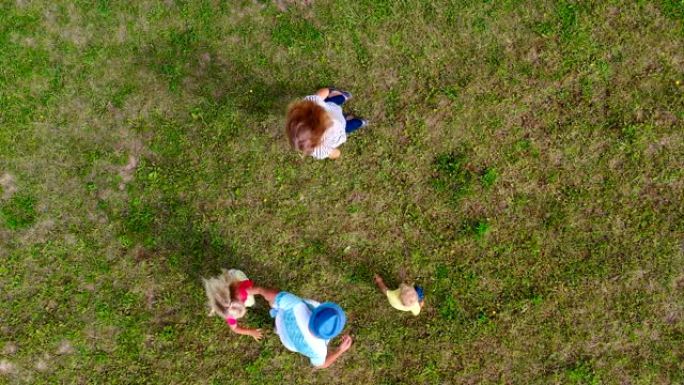 顽皮的家庭父母和小孩在公园草地上玩得开心。空中射击