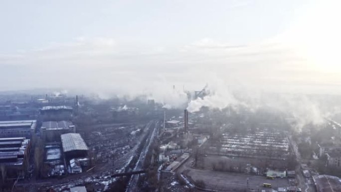 鸟瞰图。冬季工业管道冶金厂向大气排放。工厂用无人机拍摄烟囱。日出时钢厂管道的空中无人机镜头。