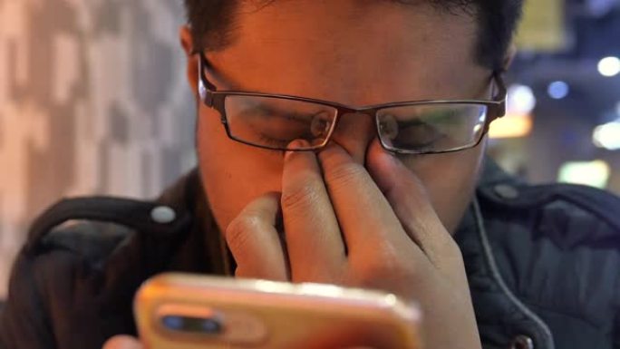 年轻人因使用智能手机而感到眼睛疼痛