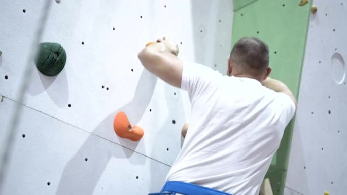 强壮的人训练在室内攀岩墙上攀岩