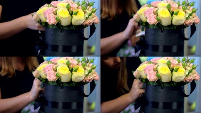 花店妇女在商店的黑匣子包装中制作玫瑰花束，特写镜头。