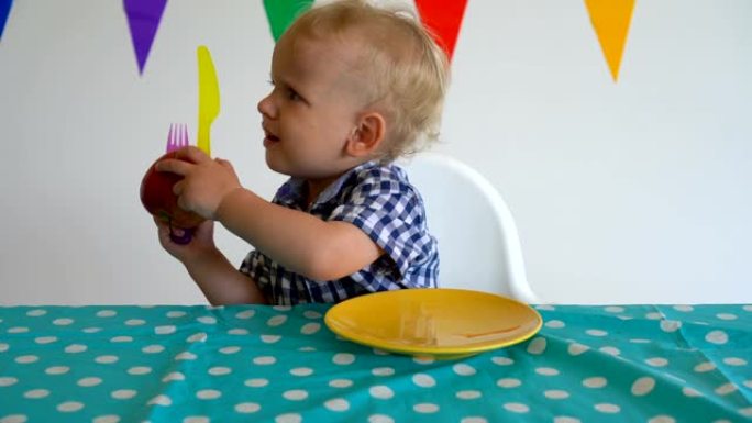 任性的男婴把盘子里的苹果扔了。万向节运动