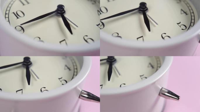 经典闹钟，白色表盘和粉色背景上的黑色箭头