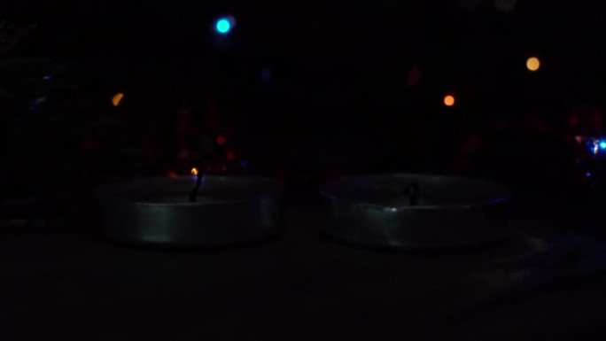 两支蜡烛在圣诞节花环，灯笼，礼物的背景上燃烧。圣诞节。