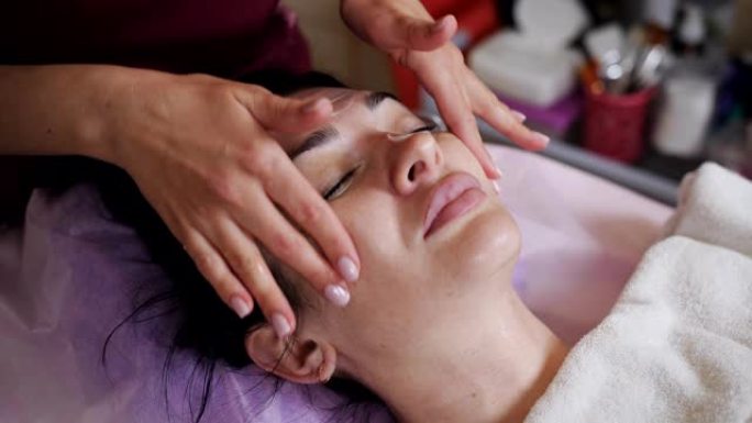 女美容师在病人脸上涂上特殊的愈合霜。
