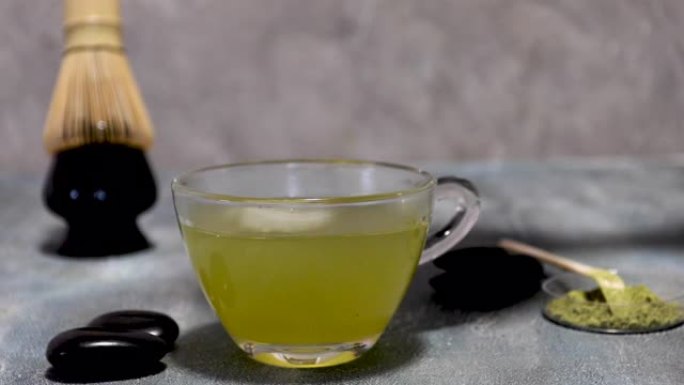 玛卡绿茶从茶壶中倒入透明杯子中，并干扰了便宜货。