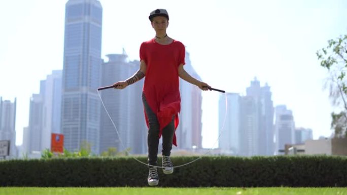 迪拜城市景观背景下跳绳跳跃的年轻女孩