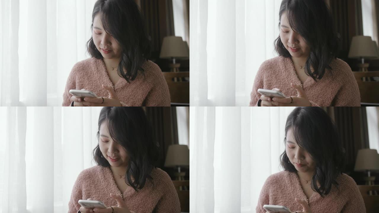 亚洲女性在智能手机上发短信并微笑。