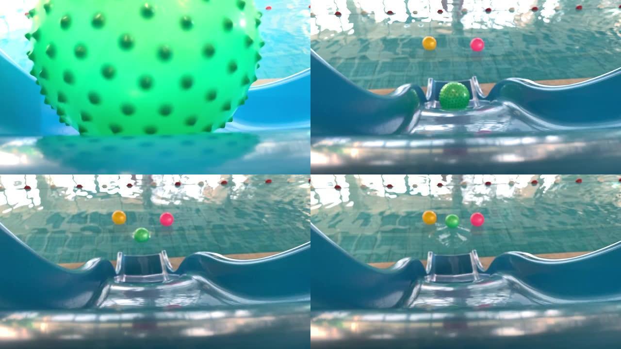 绿色球在水滑梯上滚落到游泳池