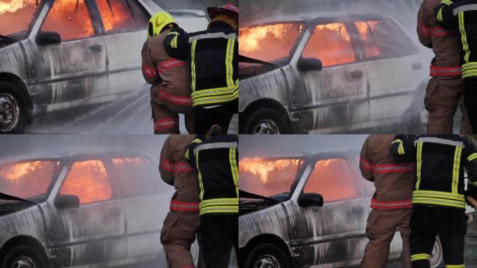 亚洲消防员穿防火服的后视图。消防人员在消防站概念的消防演习交通事故中与汽车起火。慢动作