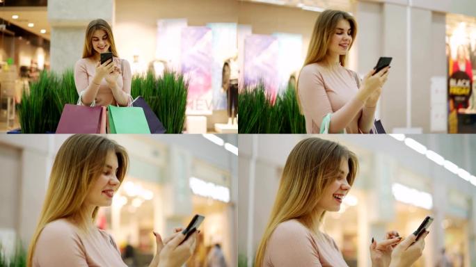 放大快乐的年轻女子站在商场的购物袋中浏览手机上的图片或短信的照片