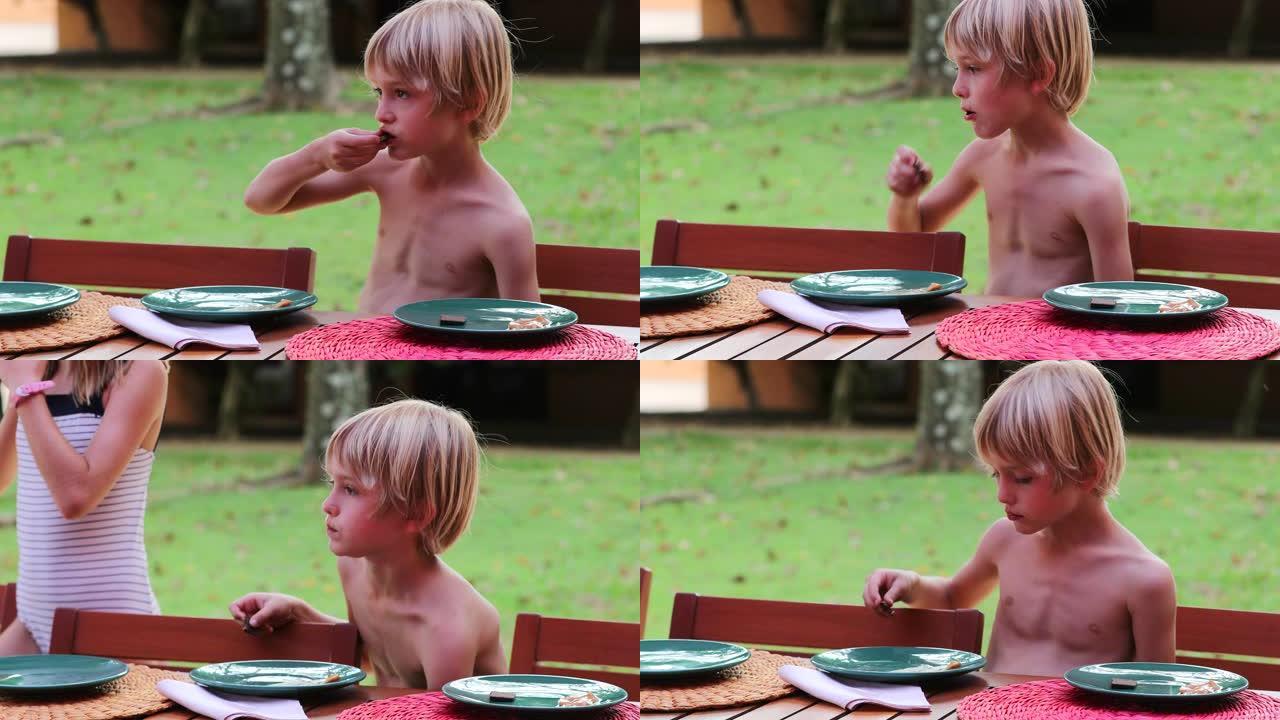 孩子在户外吃饼干，坦率英俊的金发小男孩吃甜