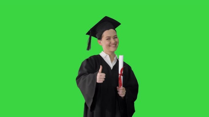 快乐的女毕业生拿着文凭，在绿屏上竖起大拇指，色键