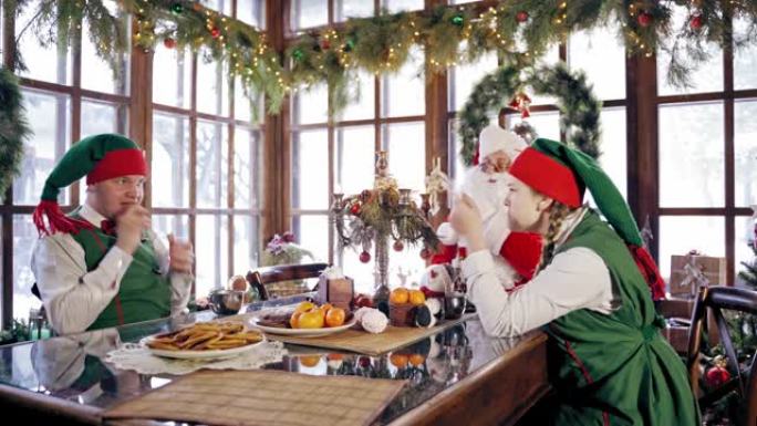 精灵和圣诞老人在圣诞节的餐桌上。