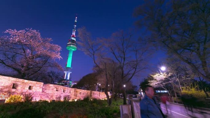 晚上春天的首尔塔和韩国N首尔塔樱花节期间的人们散步。4k延时