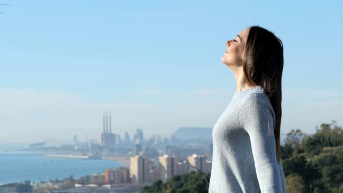 放松的女人在城市郊区呼吸新鲜空气