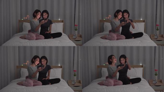 两个年轻的女性朋友晚上在床上分享时光