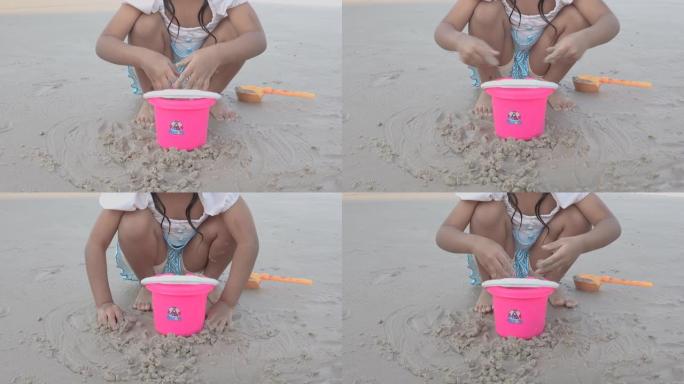 女婴喜欢在海滩上玩沙子。