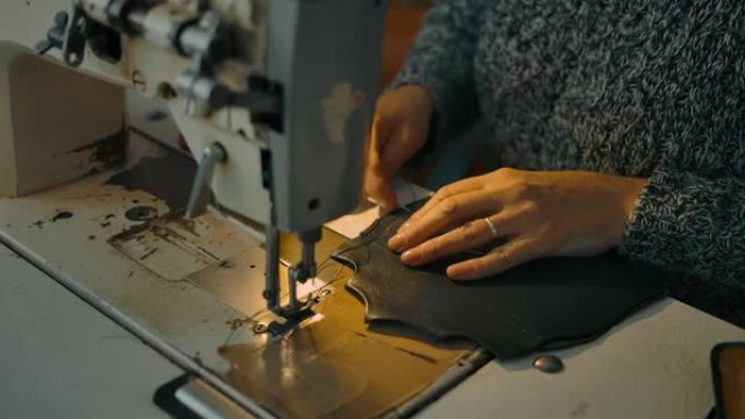 无法识别的女人在工厂为新包处理皮革