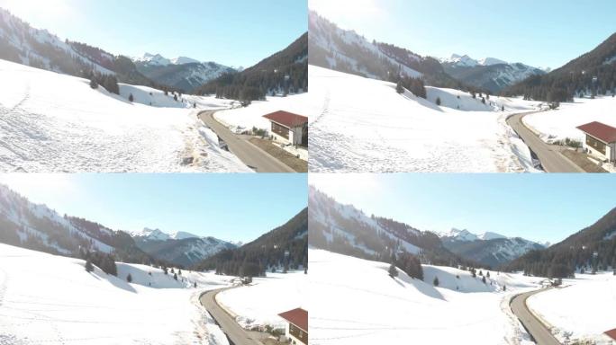 航拍奥地利伯旺的冬季，滑雪村，明亮的阳光照射在斜坡上
