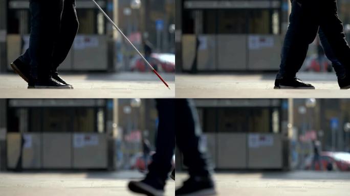 一个盲人拄着拐杖走在城市的人行道上