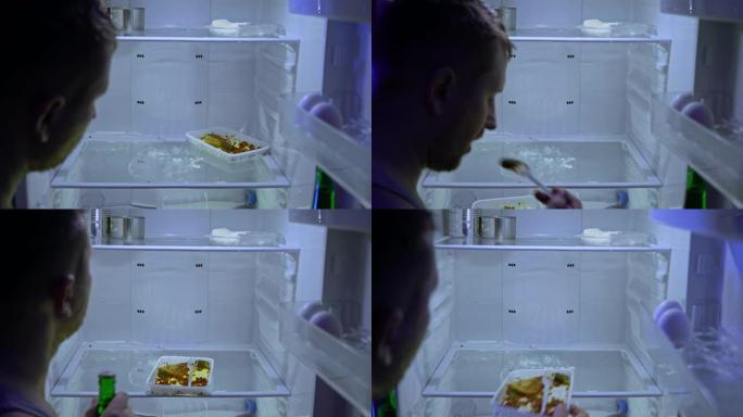 在冰箱里找食物的人。那家伙在冰箱里吃剩下的食物，然后拿了一瓶啤酒。