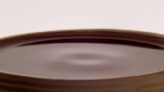 将浓缩咖啡或美式咖啡或黑咖啡滴到咖啡杯中，慢动作镜头。