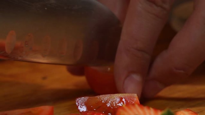 用刀将樱桃番茄切成四分之一的过程特写。