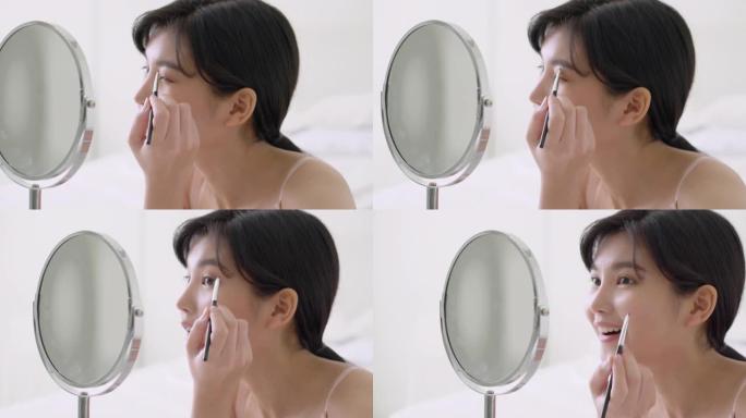 美丽的年轻亚洲女性应用化妆眉毛刷，美容亚洲女孩使用化妆品化妆风格照镜子在家，时尚女性镊子自然，生活理