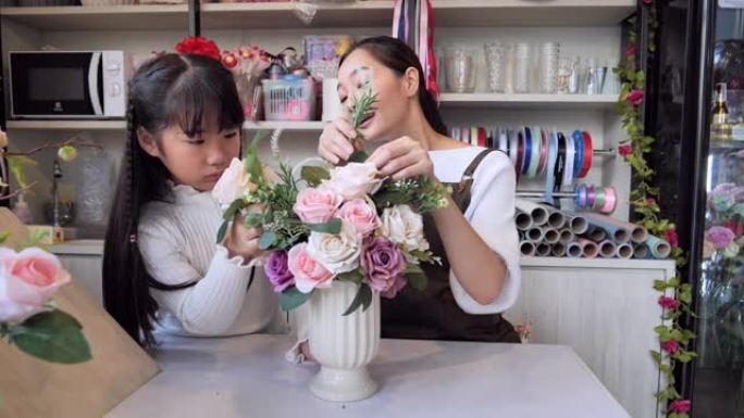一家亚洲花店的老板和他的女儿一起帮助安排商店内的鲜花以准备出售，一位日本妇女与专业花店，小型商业概念