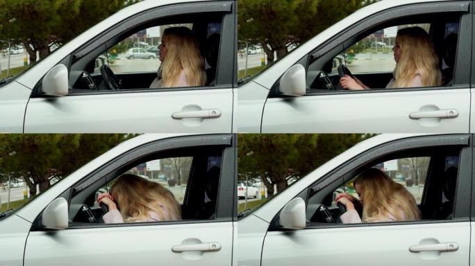 年轻的金发女人坐在车里，把手和头放在方向盘上，女孩累了，消极，情绪疲惫，压力很大