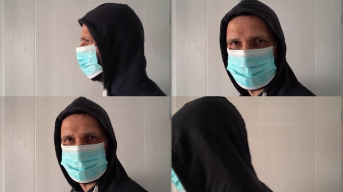 高加索成年男子的肖像，头上戴着防护医用口罩和兜帽，以防止病毒细菌大流行污染，对着镜头近距离走开