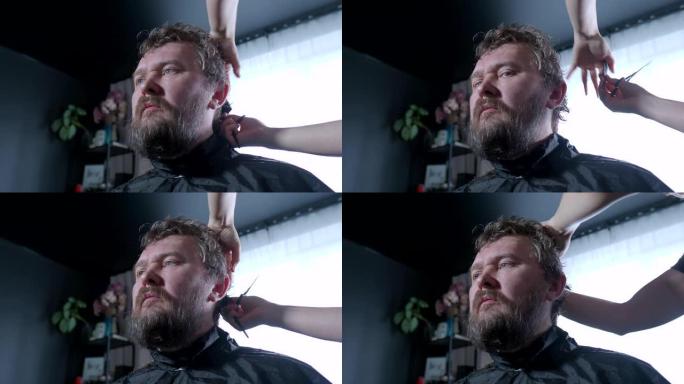 一个女人正在给一个男人理发