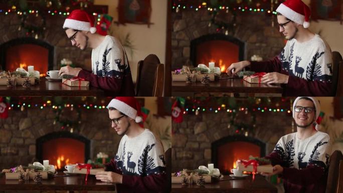 大胡子的男人坐在壁炉附近的礼物上系蝴蝶结，戴着圣诞帽纸包装盒，用杉木树枝，圆锥体，甘蔗糖果装饰，然后
